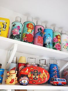 the shelves are filled with many different types of tins and other decorative items on them