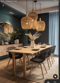 a dining room table with chairs and lights hanging from the ceiling