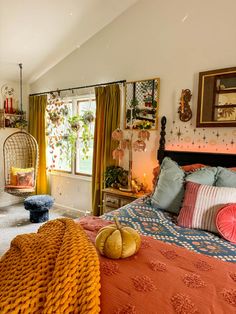 a bedroom with an orange bed spread and hanging decorations