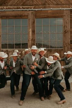 a group of men in suits and hats hugging each other