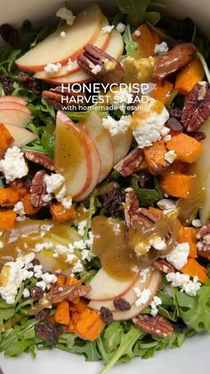 a salad with apples, cheese and pecans on top is shown in a white bowl