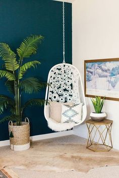 a living room with a hanging chair and potted plant