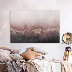 a bedroom with a large painting hanging above it's headboard and pillows on the bed