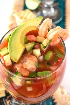 a bowl filled with shrimp, avocado and tomato soup