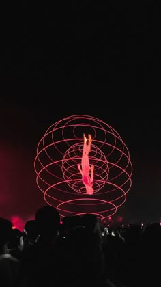 a person standing on top of a large object in the air with lights behind them