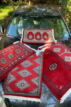 four red rugs on the hood of a car