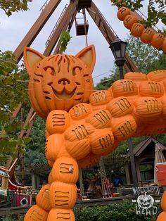 an orange cat made out of pumpkins in front of a ferris wheel