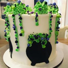 a white cake with green and purple decorations on it's side, sitting on a table