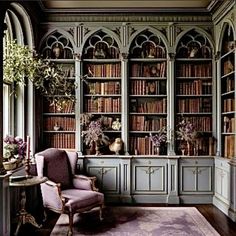 a room with many bookshelves filled with lots of bookcases and flowers