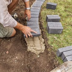 a man laying bricks on the ground