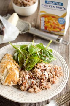 a white plate topped with meat and veggies next to a carton of milk