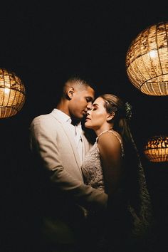 a man and woman standing next to each other in front of some lights at night