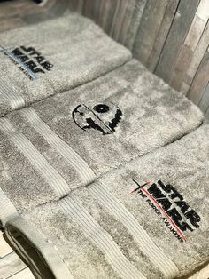 three towels are sitting on top of a wooden bench with the words, star wars written on them