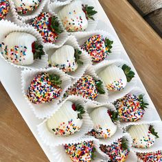 chocolate covered strawberries with sprinkles are arranged on a white platter