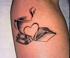 a tattoo with books and a cup on it