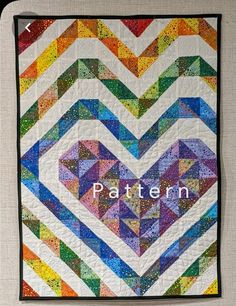 a colorful quilt with the word pattern written on it in front of an image of a heart