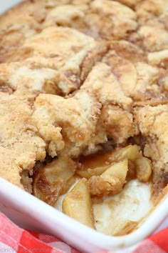 an apple cobbler in a white dish on a red and white checkered table cloth