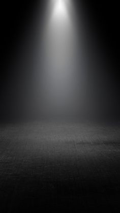 an empty room with two spotlights on the wall and one light at the end