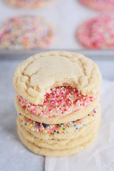 a stack of cookies with sprinkles on top and one cookie in the middle