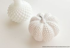 two white pumpkins sitting next to each other on a table