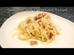 a white plate topped with spaghetti and meat