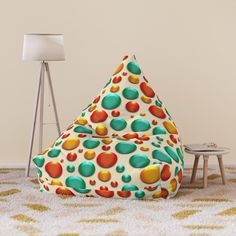 a colorful bean bag chair sitting on top of a white floor next to a lamp