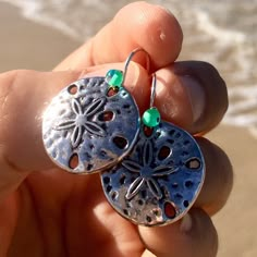 gorgeous and elegant silver sand dollar earrings perfect gift for beach lovers! * silver sand dollar * hypoallergenic stainless steel silver french hook ear wires  * transparent teal glass accent beads * add a matching bracelet! Handmade by me with Aloha in Hawaii they arrive ready for gifting with my LIVE ALOHA card, inside a delicate deep ocean blue organza bag. *to ensure safety in transit, earrings are now shipped inside a cute, reusable acrylic jar along with my Live Aloha card and organza bag* SEE ALL MY EARRINGS HERE: https://www.etsy.com/shop/LOphoto808?ref=br_feed_17&br_feed_tlp=art§ion_id=17783609 shipping additional items is FREE!! please contact me here: https://www.etsy.com/conversations/new?with_id=30970463 if you need assistance with ordering or have any questions. PLEASE VI Silver Dangle Earrings For Vacation, Silver Earrings For Summer Vacation, Handmade Silver Jewelry For Beach Season, Ocean-inspired Silver Jewelry For The Beach, Silver Ocean-inspired Jewelry For The Beach, Silver Ocean-inspired Jewelry For Beach, Beachy Silver Vacation Jewelry, Ocean-inspired Silver Beach Jewelry, Nickel Free Sterling Silver Jewelry For Beach