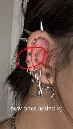 a woman with piercings on her ears and behind the ear is a pair of scissors