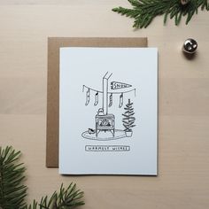 a card with a drawing of a stove and christmas tree on the table next to it