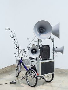 a bike that is sitting next to a speaker on the back of it's stand