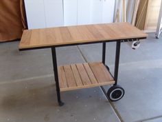 a wooden table with wheels on it in a room