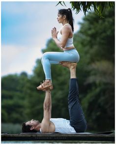 a man and woman doing yoga on the water