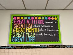 a bulletin board hanging on the wall above a classroom door that reads great attitude comes a great day, which becomes a great month