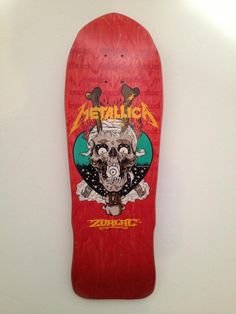 a red skateboard hanging on the wall with a skull and flames painted on it