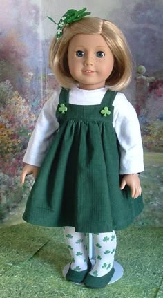 the doll is wearing a green dress with shamrocks on it's sleeves and feet