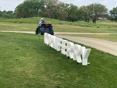 a man on a lawn mower cutting the letters spelling happy