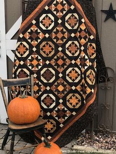 a quilted pumpkin sitting on top of a chair in front of a door with a black background