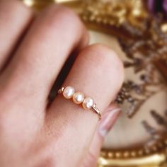 Three Pink Pearl Ring ✨ Three Stone Ring with Genuine Pink Pearls and 14K Gold Filled, Rose Gold Filled & Sterling Silver. June Birthstone Ring ✨💖 Triple pink pearl ring. Tiny & dainty ring with three small rose gold pearls. Make a very cute pinky ring.Sizing:• Gemstone Diameter: 4 mm• Ring Band: 0.8 mm• Handmade in your ring size with genuine freshwater pearls.• Gold-filled and sterling silver are known for their lasting quality. This will last for decades and is considered a lifetime piece of Rose Gold Pearl Ring, Pearl Ring Design, Pink Pearl Ring, Jewelry Making Rings, June Birthstone Ring, Gold Pearl Ring, Rose Gold Pearl, Pink Pearls, Freshwater Pearl Ring