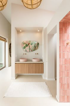 a bathroom with two sinks and a mirror on the wall next to a rug in front of it