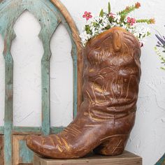 a pair of cowboy boots sitting on top of a wooden block