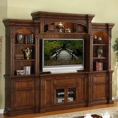 a living room with a large entertainment center in it's centerpiece and a flat screen tv mounted on the wall