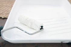 a white tray with a towel on it and a metal bar attached to the edge