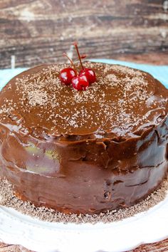 a chocolate cake with two cherries on top