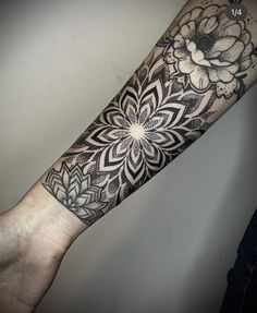 a black and white flower tattoo on the arm