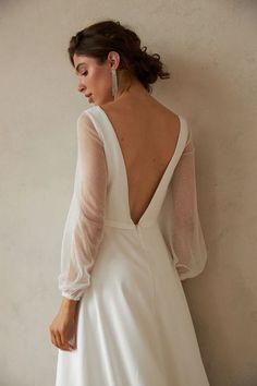 the back of a woman's wedding dress, with long sleeves and open shoulders