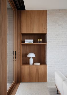 a white couch sitting next to a wooden shelf