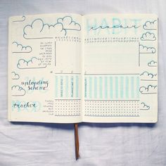 an open planner book with blue clouds and the word habit written on it in cursive writing