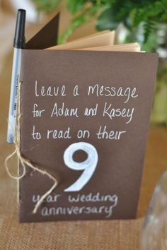 a brown book with white writing on it and a note attached to the cover that says leave a message for adam and kasey to read on their 9 year wedding anniversary