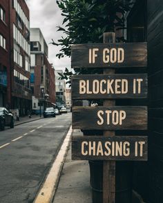 a wooden sign that says if god blocked it stop chasing it on the side of a street