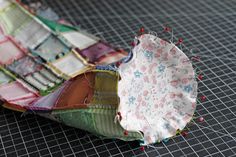 an open umbrella sitting on top of a table next to some pins and needles in it